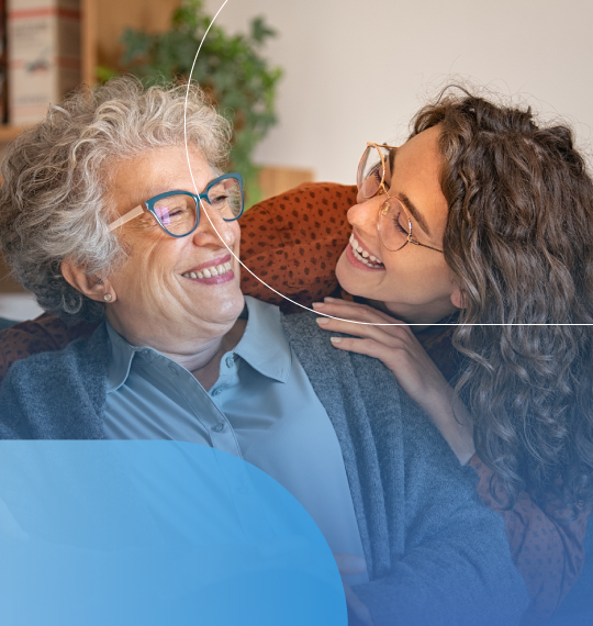Immagine di giovane donna e donna anziana che sorridono abbracciate in casa con elementi grafici arrotondati.
