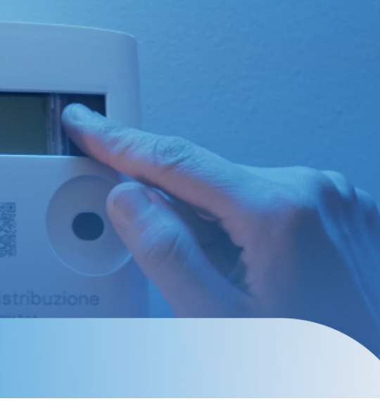 Immagine di un dito che preme il pulsante di un contatore elettrico su sfondo blu con elementi grafici arrotondati.
