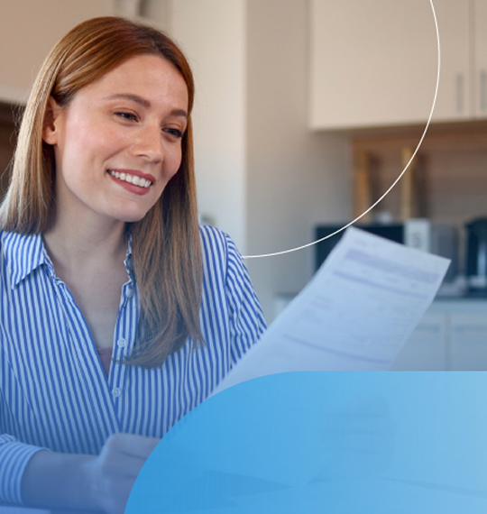 Immagine di una donna sorridente in ambiente domestico che tiene tra le mani una bolletta con elementi grafici arrotondati.
